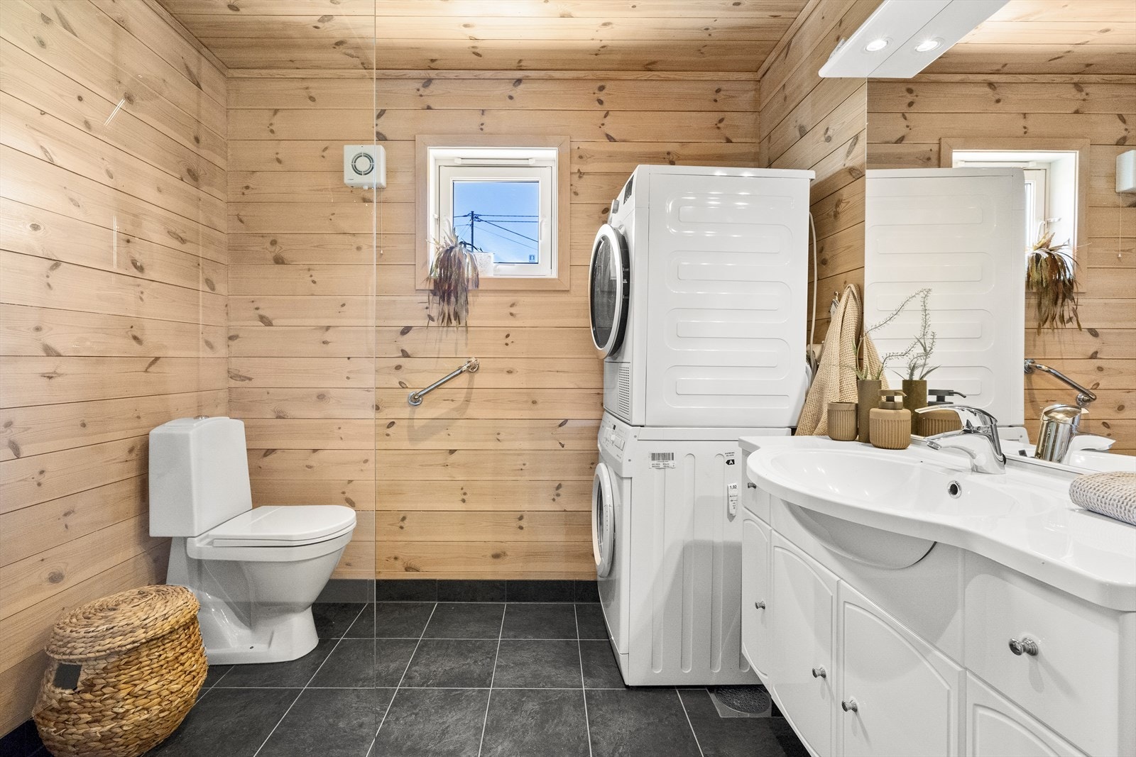 Bad/vaskerommet består av speil, servant med seksjon, toalett, dusj og opplegg for vaskemaskin. Galleribilde