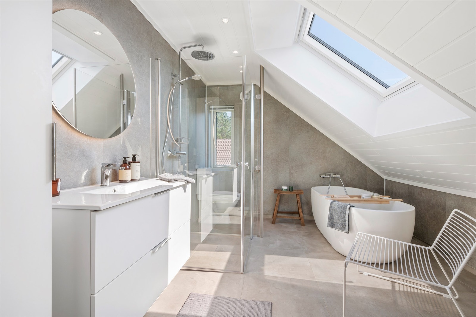 Videre er badet utstyrt med servantskap med speil med lys, toalett, dusjhjørne med regndusj og badekar. Galleribilde