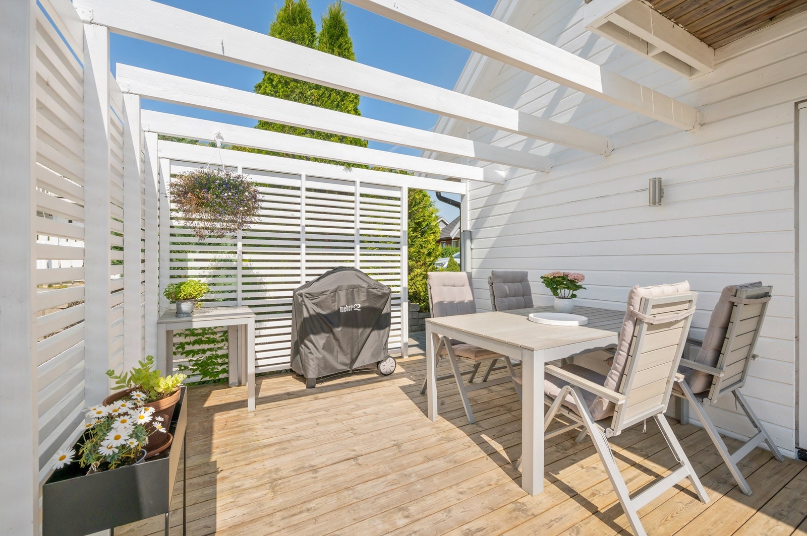 Det er bygget en flott pergola med levegg, praktisk for å holde vinden unna. Galleribilde