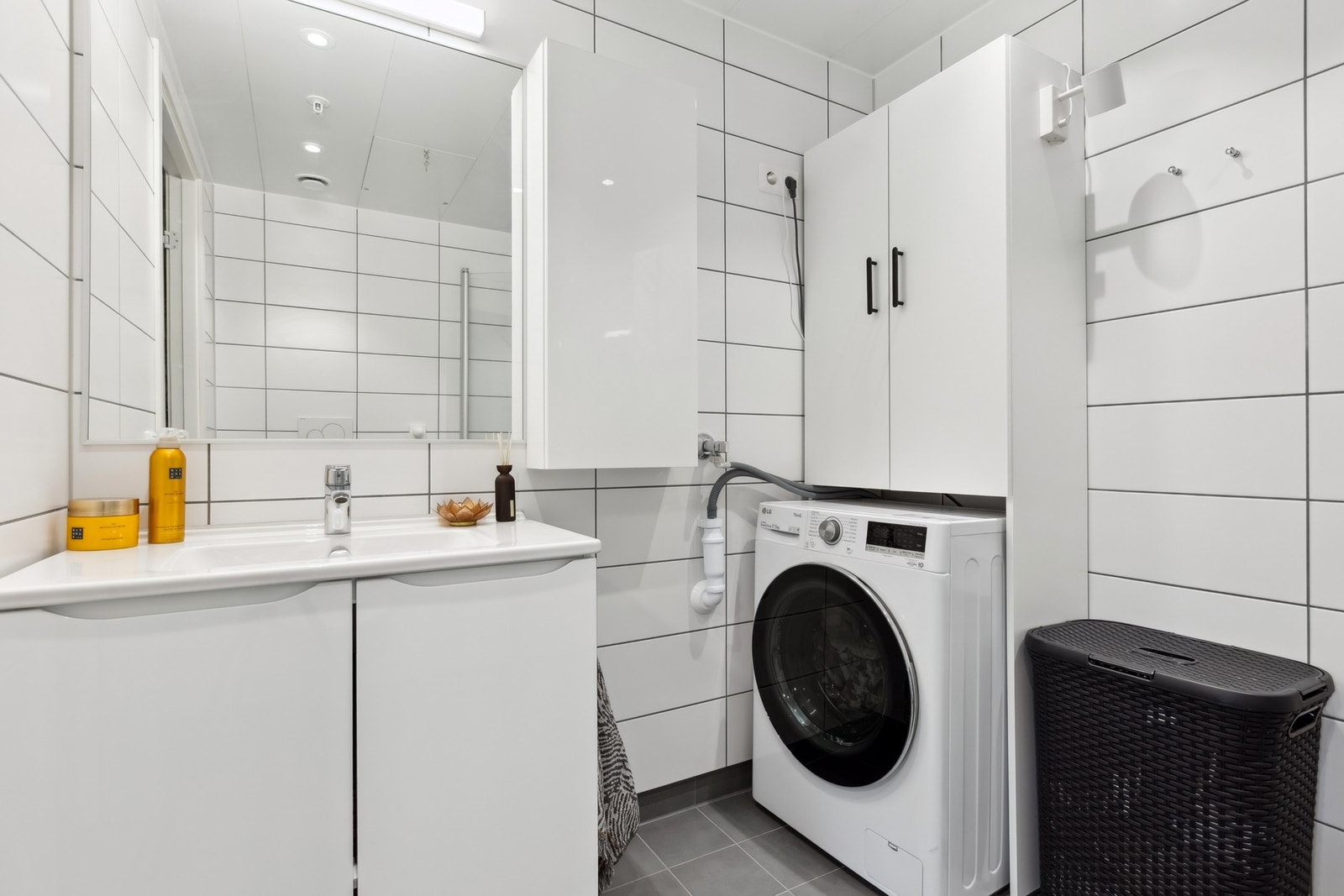 Baderommet er utstyrt med vegghengt servantinnredning, vegghengt toalett, dushjørne med dører og opplegg for vaskemaskin. Galleribilde