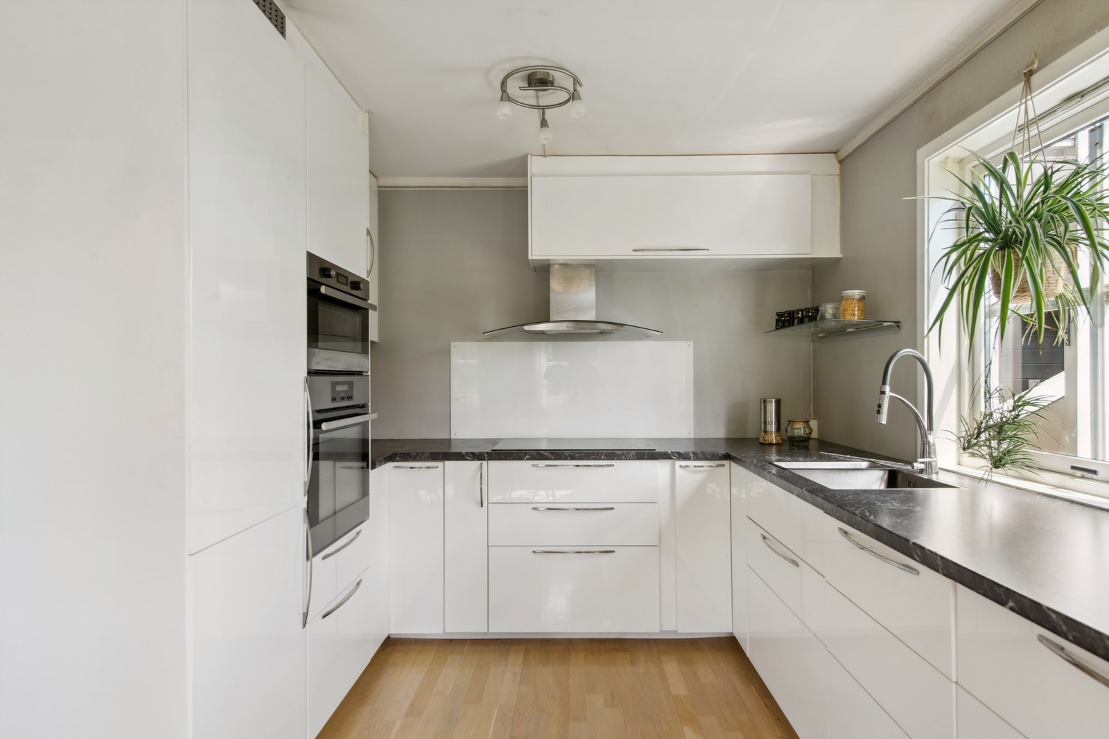 Kjøkkenet er utstyrt med integrert kombiskap, induksjonstopp, stekeovn og oppvaskmaskin. Ventilator med utluft er plassert over kokesonen. Galleribilde