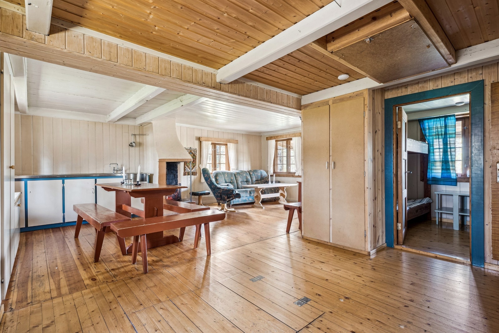 Åpen stue- og kjøkkenløsning med lakkerte tregulv og synlige bjelker skaper lun atmosfære. Galleribilde