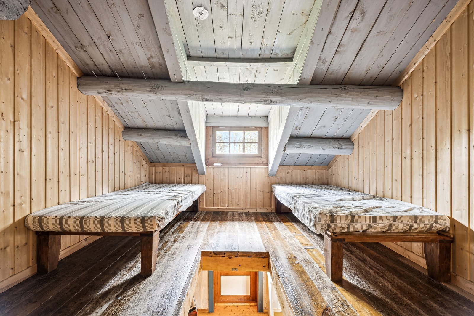 Hems med lav takhøyde, synlige bjelker. Merk at rommet ikke er godkjent til varig opphold Galleribilde