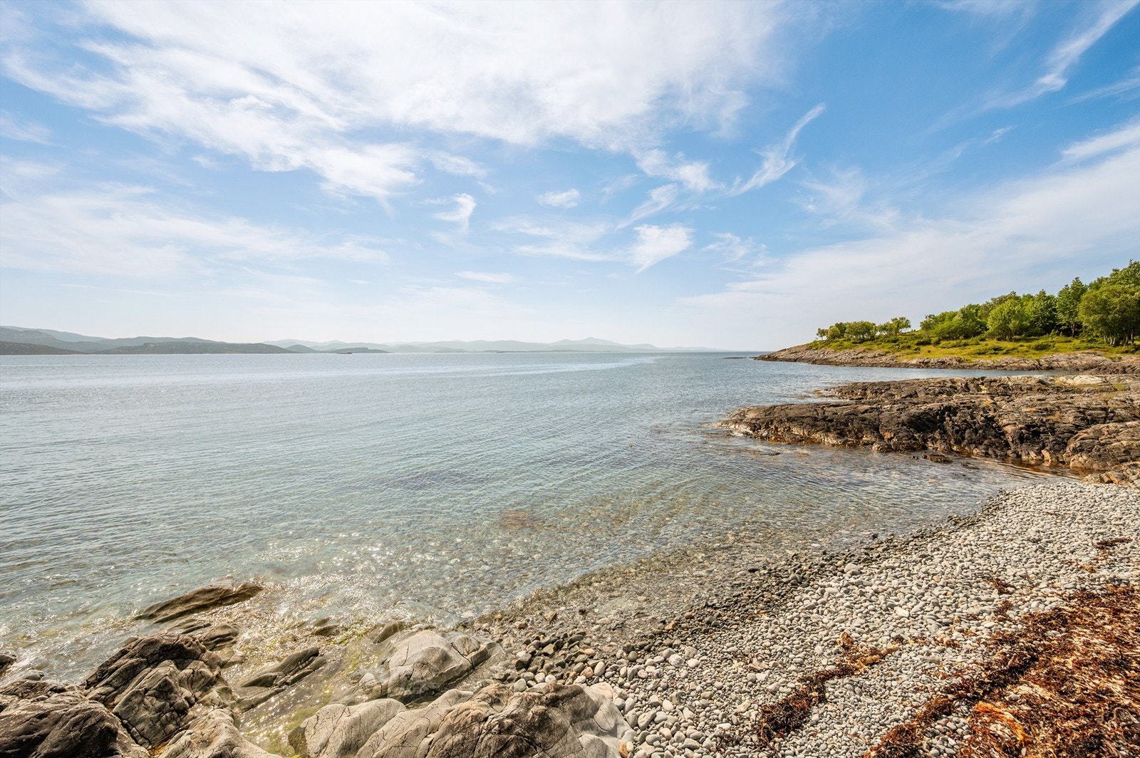 Meget pent opparbeidet naturtomt som ligger skjermet til fra naboene. Egen strandlinje med rullesteiner. Galleribilde