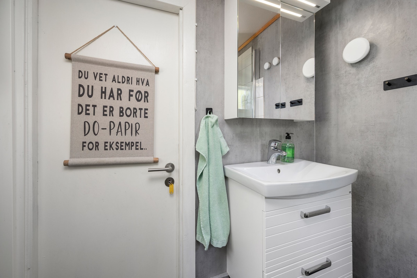 Badet har servantskap med overskap med speil og lys. Galleribilde