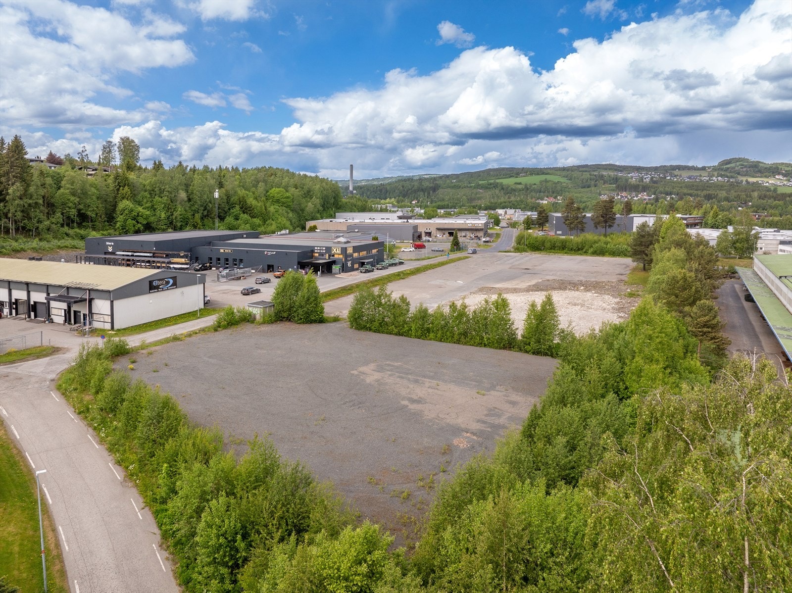 Tomten er begge parsellene som synes, grusplassen og den asfalterte delen med rester etter bygg. Galleribilde