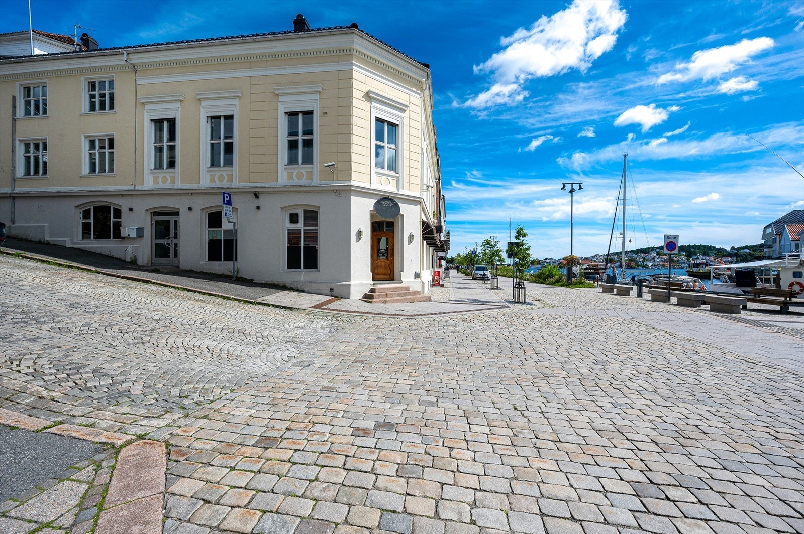 Pent opparbeidet uteområde med brosteinsbelagte gater og beplantninger Galleribilde