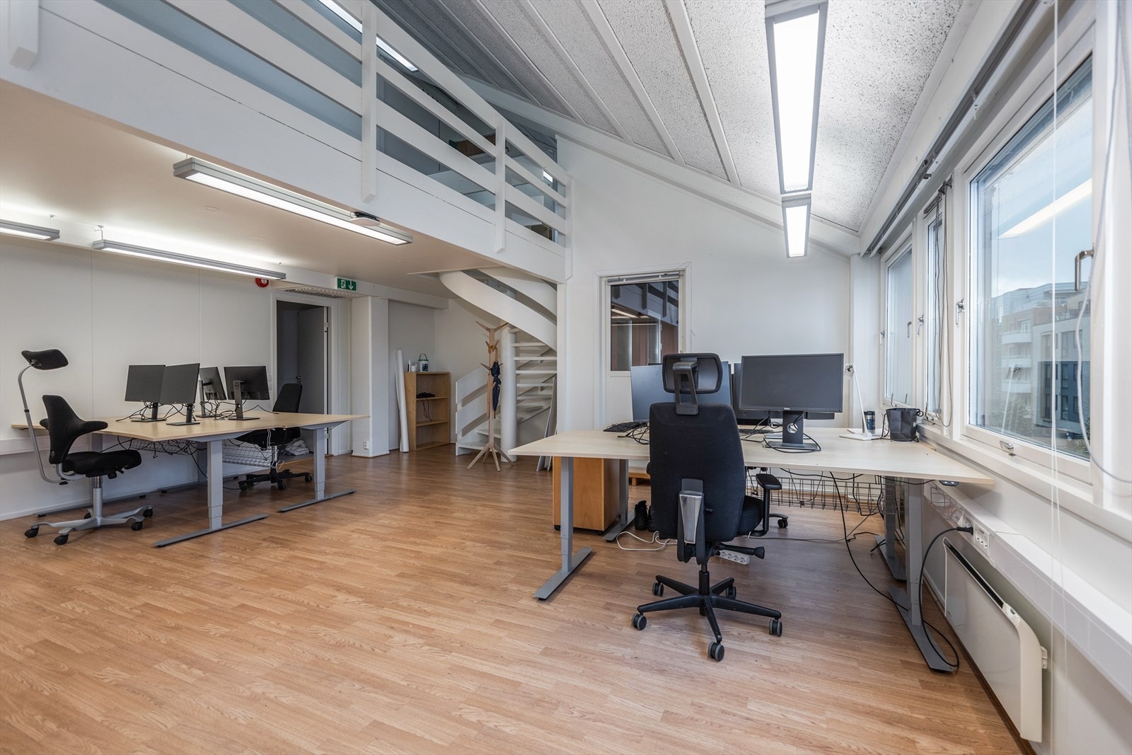 Fra møterom/åpent kontorlandskap er det god takhøyde og trapp opp til mesanin. Galleribilde