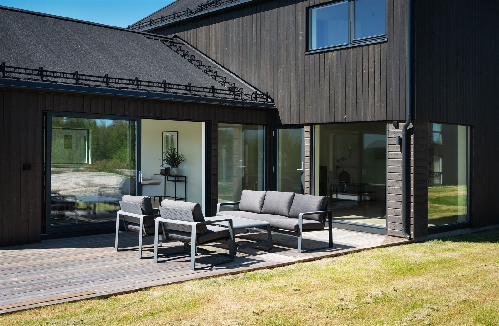 Bred skyvedør åpner opp fra kjøkken og gjør uteplassen til et ekstra rom på sommeren Galleribilde
