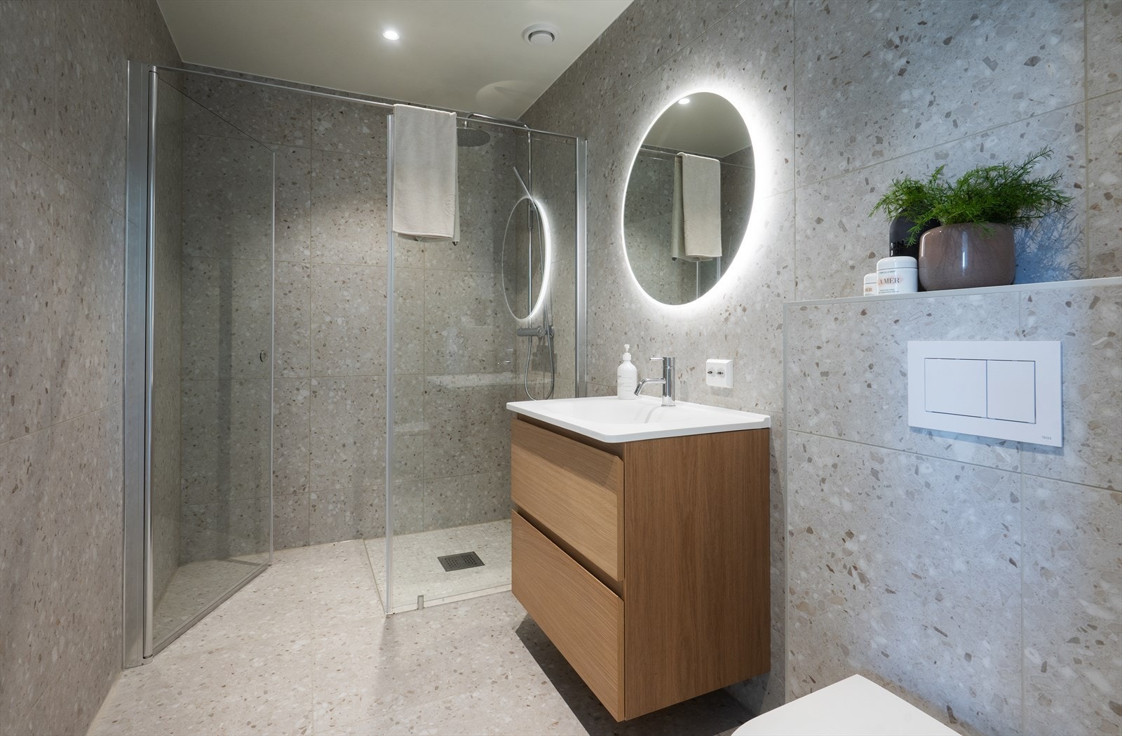 Lekkert baderom med stor fliser som står i stil med øvrig innredning Galleribilde