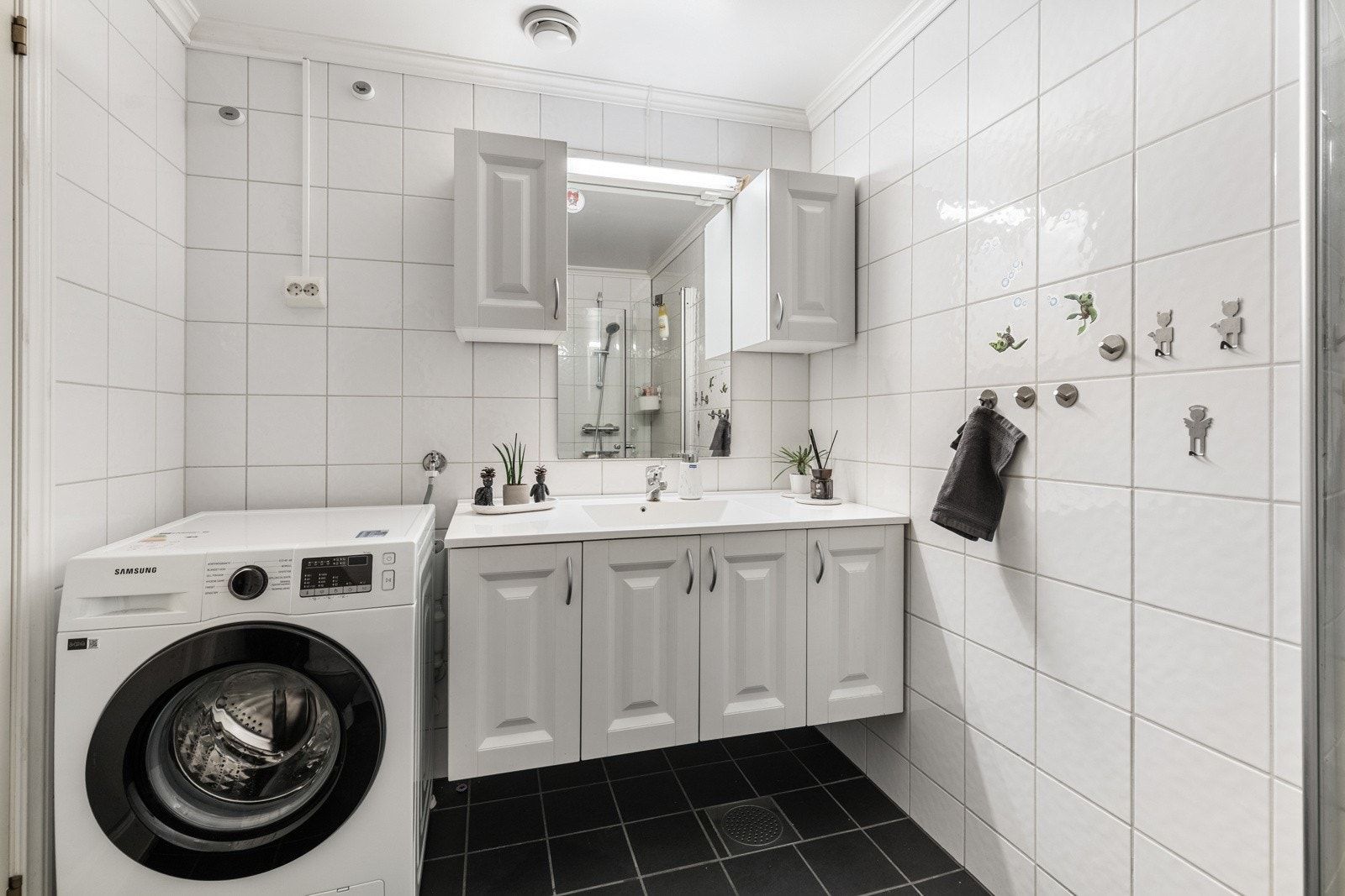 Leiligheten har et velholdt og pent bad med hvite fliser på veggene og koksgrå fliser på gulv med elektrisk gulvvarme. Galleribilde