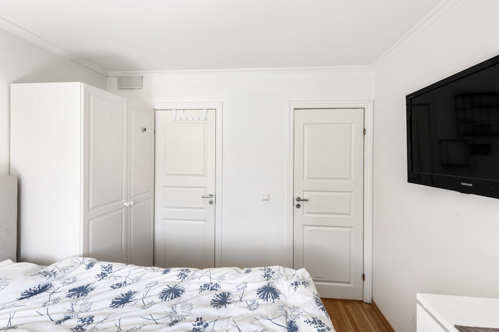 Hovedsoverommet er holdt i en stilren kombinasjon med hvitmalte vegger mot gyllent parkettgulv. Galleribilde