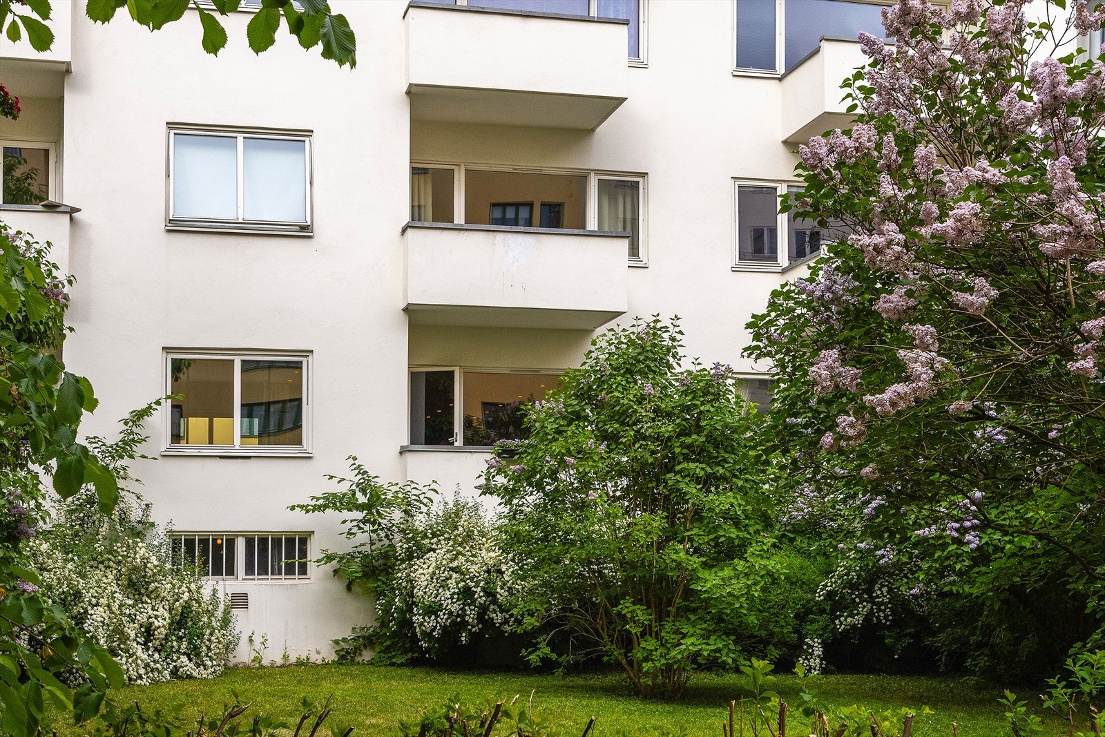Leiligheten sett fra sameiets bakgård. Merk deg hvor høyt fra bakkeplan man er på denne siden. Galleribilde
