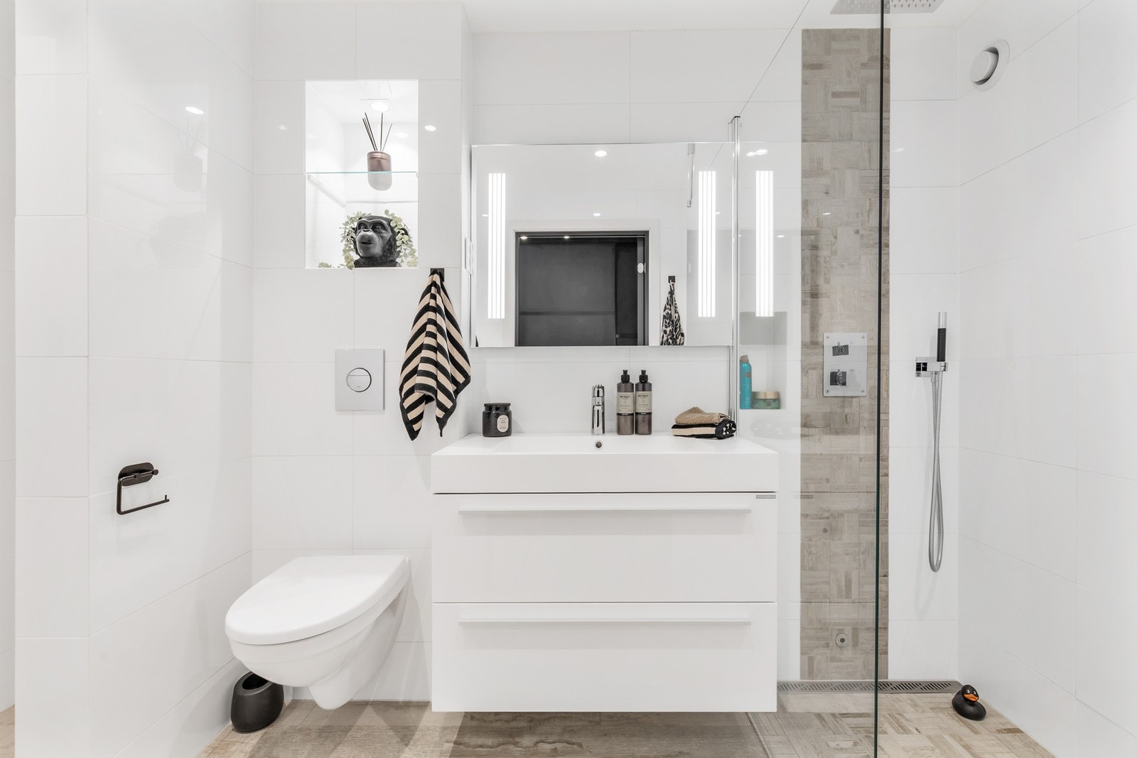 Delikat bad med tidsriktig fliser og innredning - komplett med dusj, servant, lysspeil og meget god skap- og hylleplass. Oppgradert i 2025 med bl.a. malt himling, fornying av silikon og fuging. Galleribilde