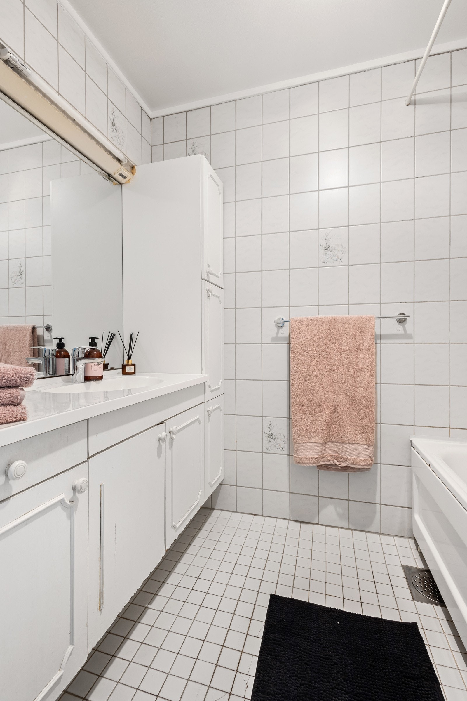 Baderom innredet med bla. badekar med dusj og servantinnredning Galleribilde