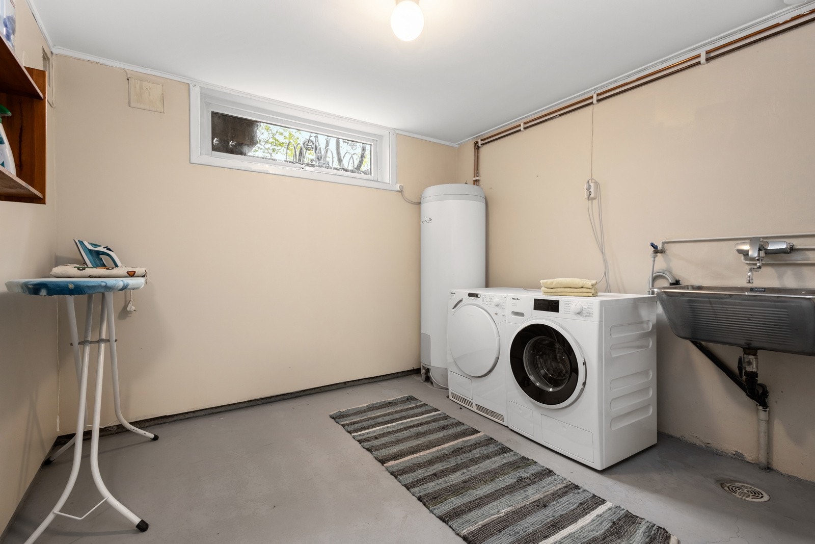 Romslig vaskerom med opplegg for vaskemaskin og tørketrommel Galleribilde