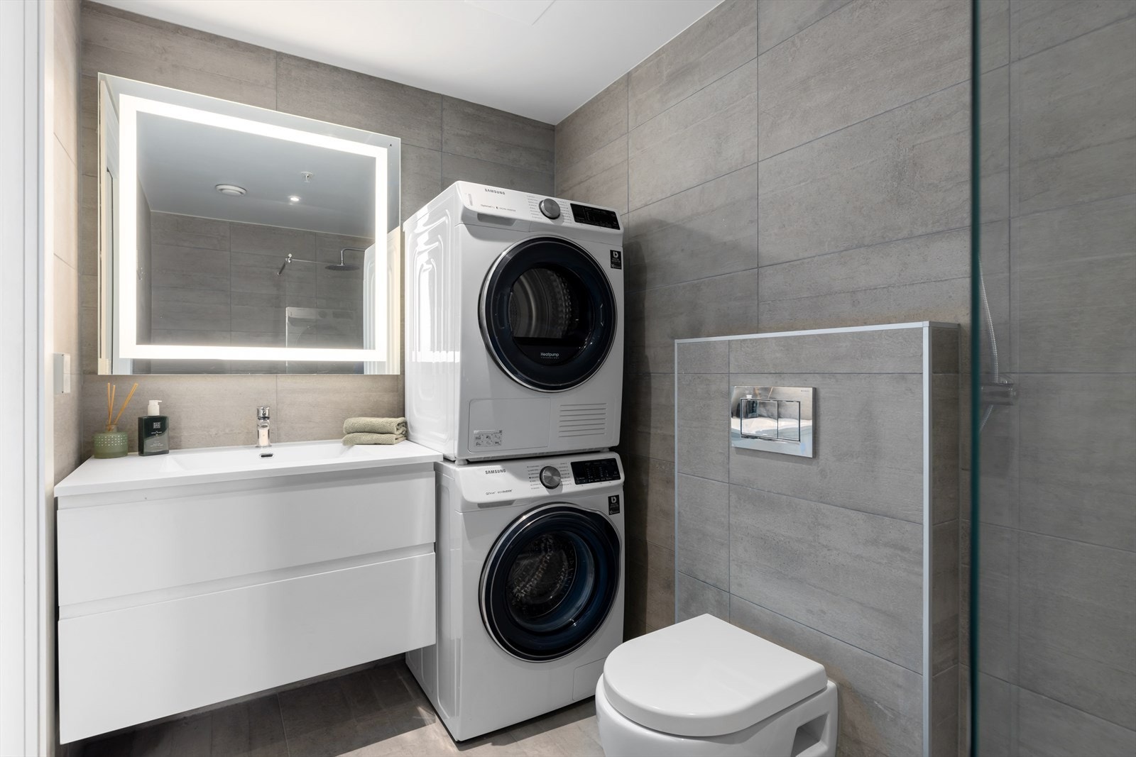 Lekkert helfliset baderom utstyrt med servant i skap, speilskap, vegghengt toalett og hvitevarer fra Siemens. Gulvvarme og mekanisk avtrekk Galleribilde