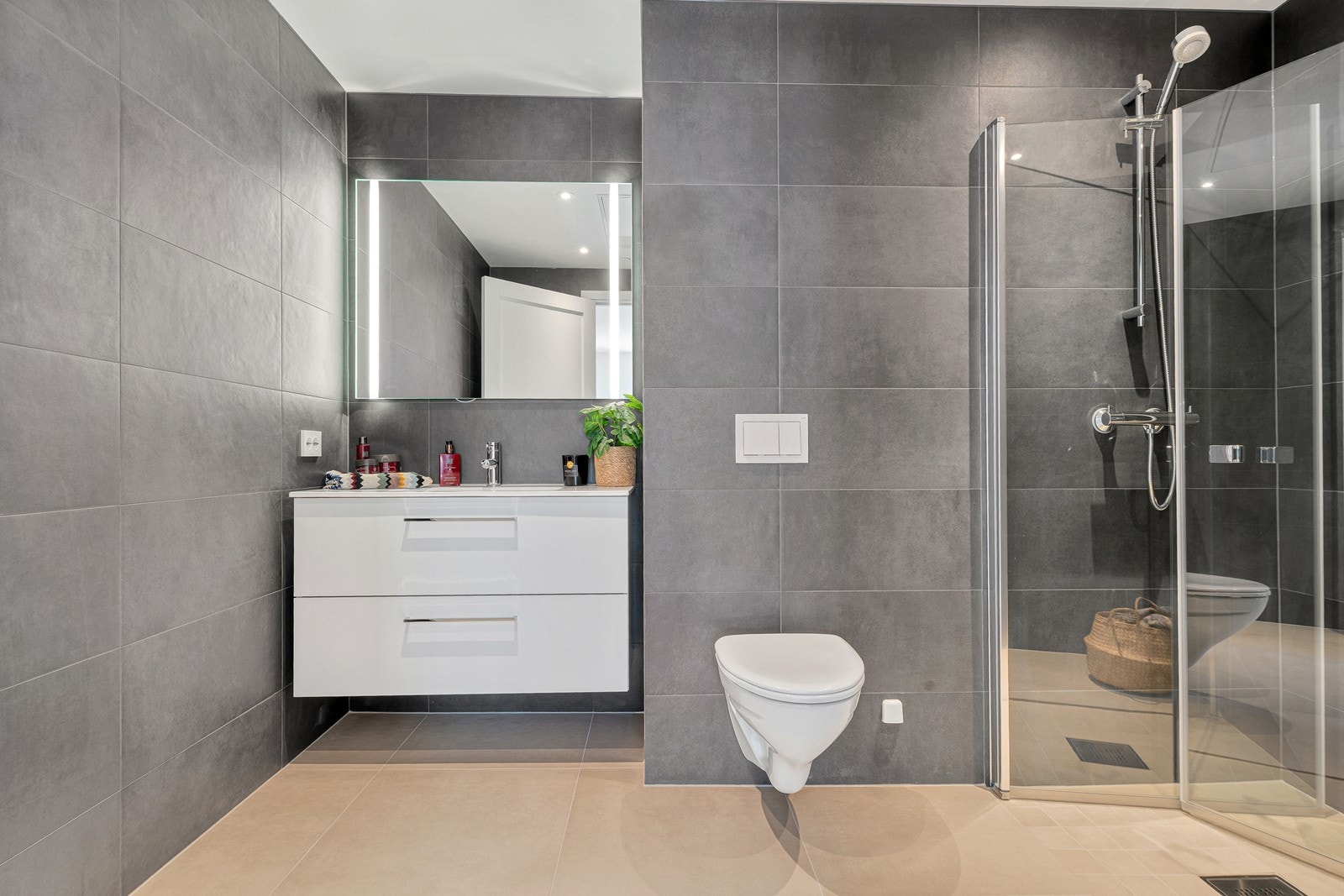 Smakfult bad med flislagte overflater og et moderne utrykk Galleribilde