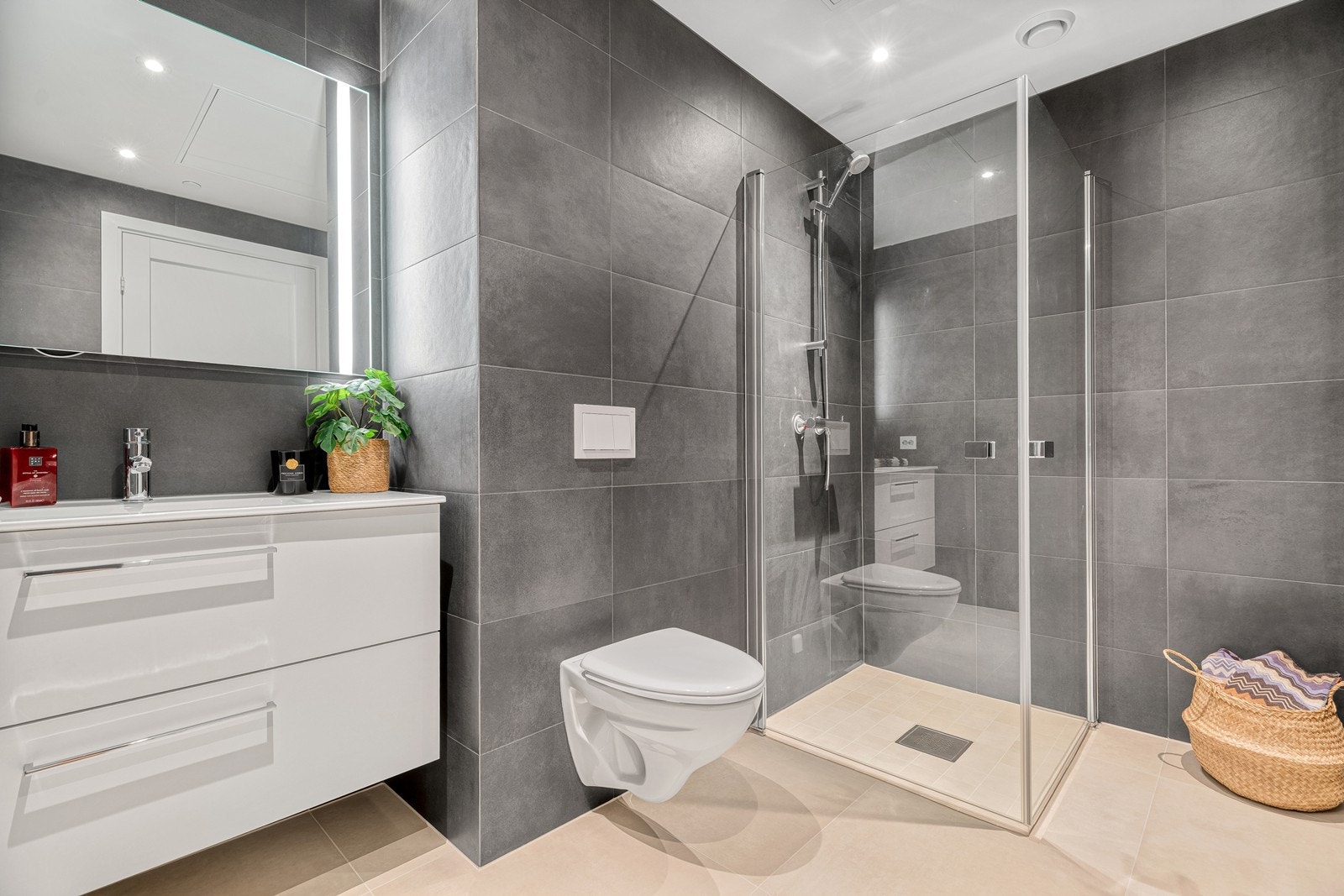 Badet er innredet med nedfelt servant, vegghengt toalett og dusjhjørne med innfellbare dører. Varmekabler i gulv Galleribilde