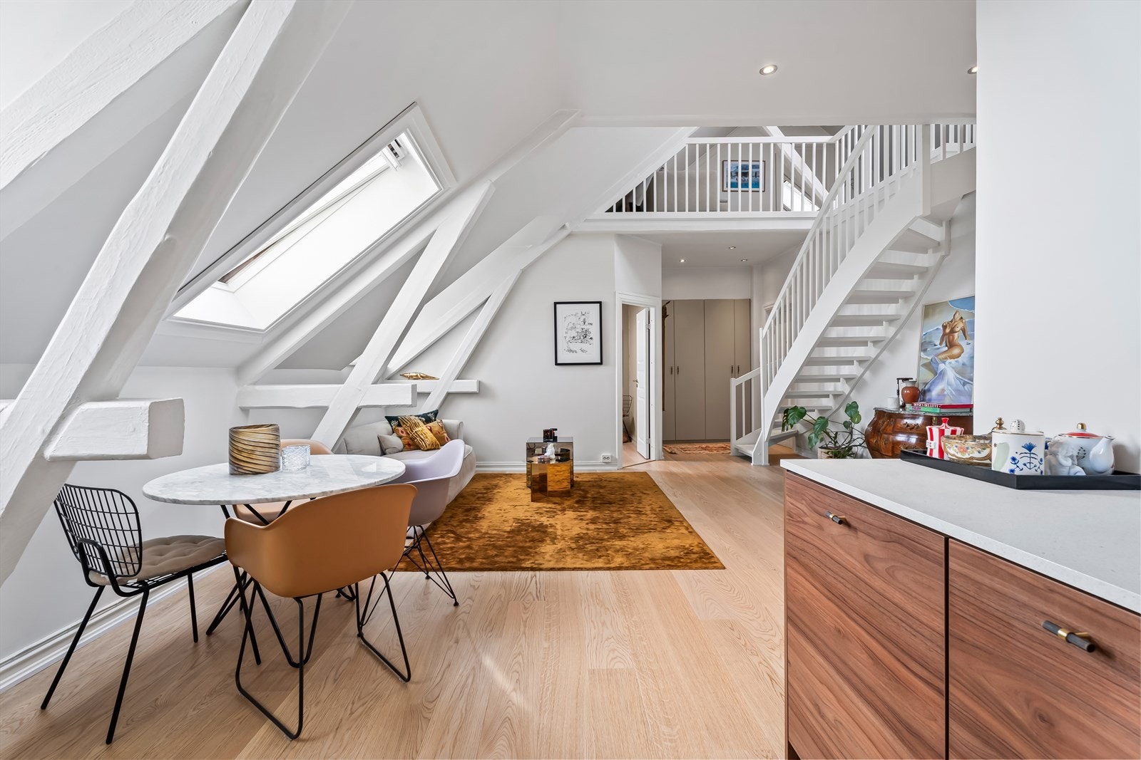 Synlige takbjelker og en rustikk murvegg tilfører særpreg og karakter, mens nye detaljer som dørhåndtak og strømkontakter bidrar til et helhetlig og flott uttrykk Galleribilde