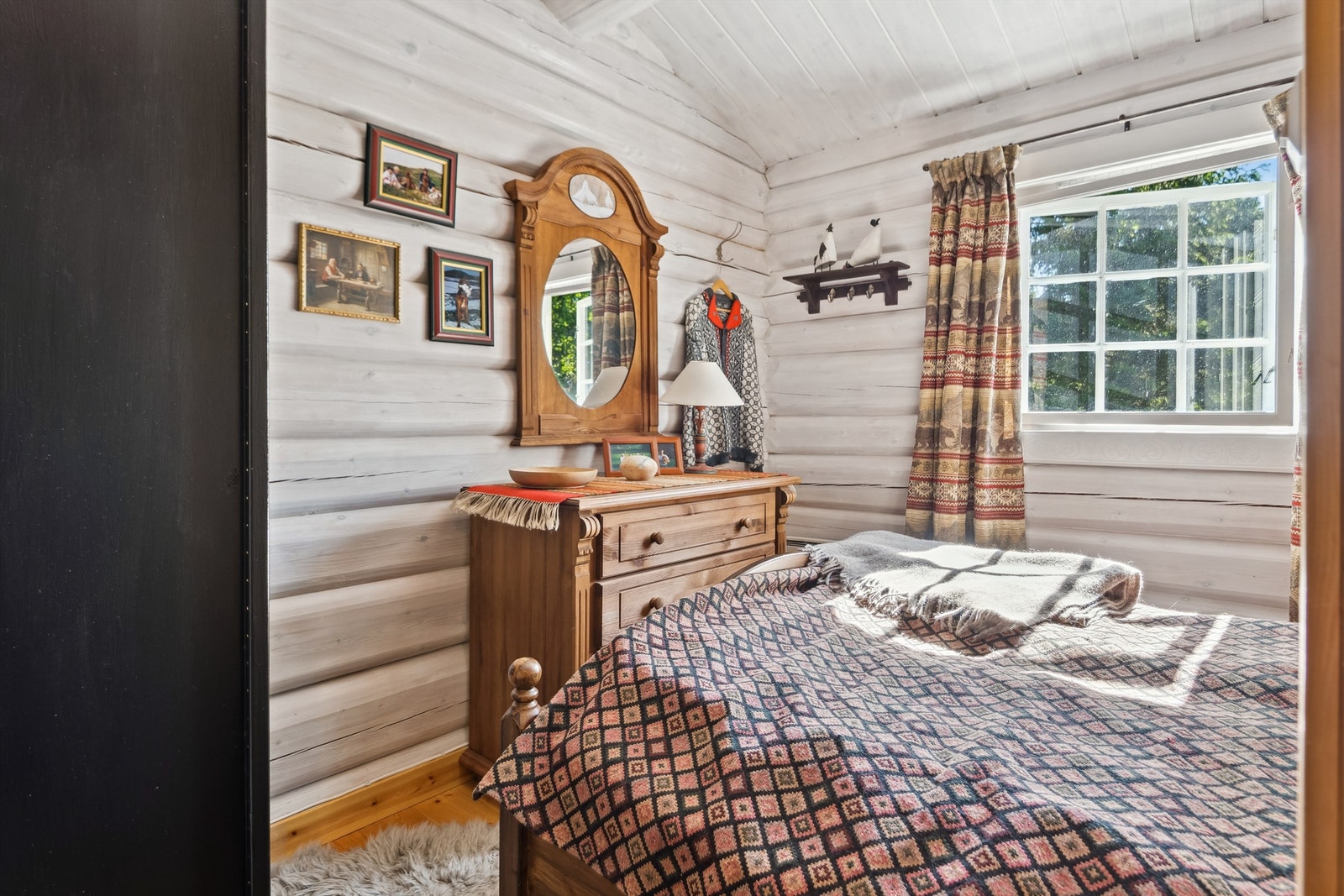 Soverom med hvitmalte tømmervegger og mulighet for både dobbeltseng og oppbevaring. Galleribilde