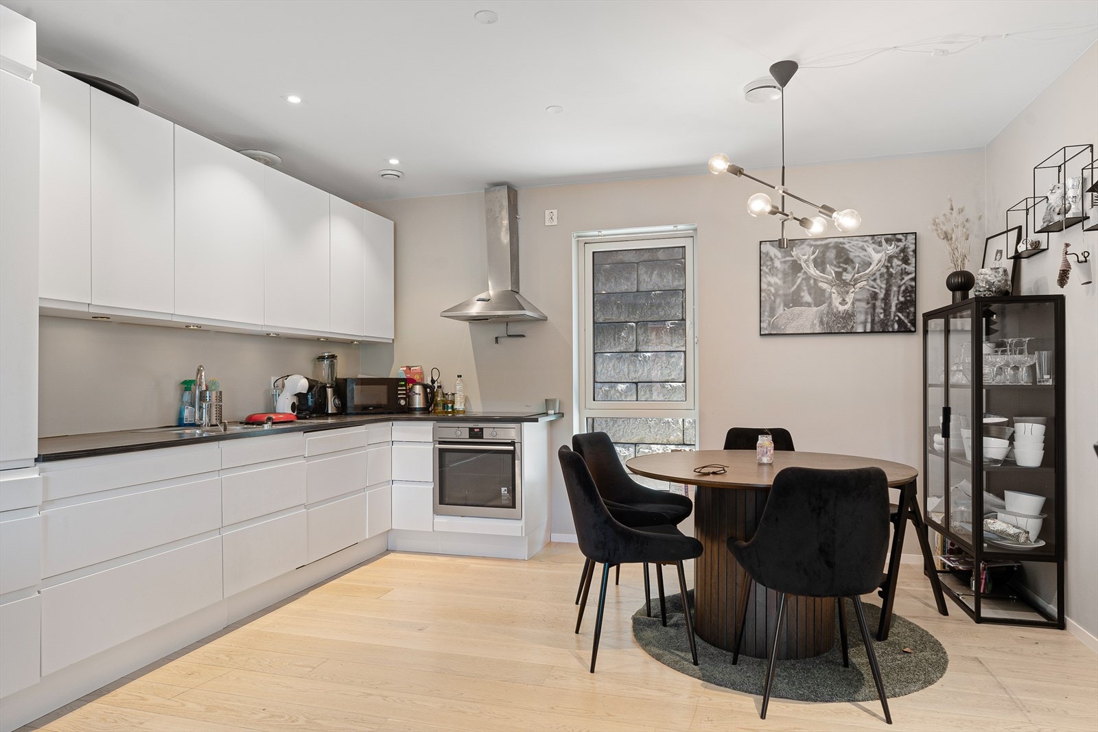 Monter-kjøkken med hvite fronter, mørk benkeplater. Integrert komfyr, platetopp, oppvaskmaskin og kjøl/fryseskap Galleribilde