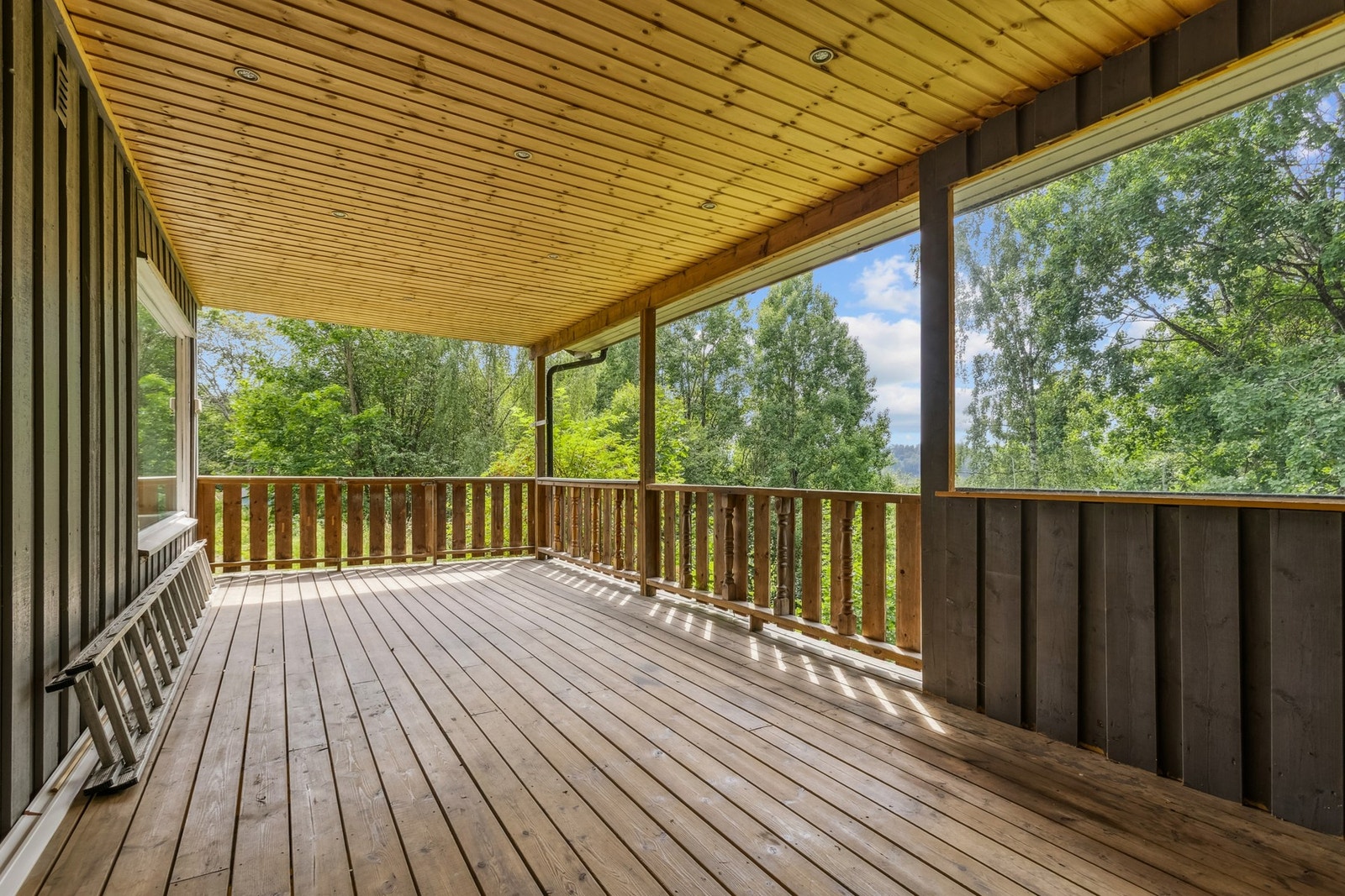 Stor terrasse med takoverbygg og downlights i taket. Galleribilde