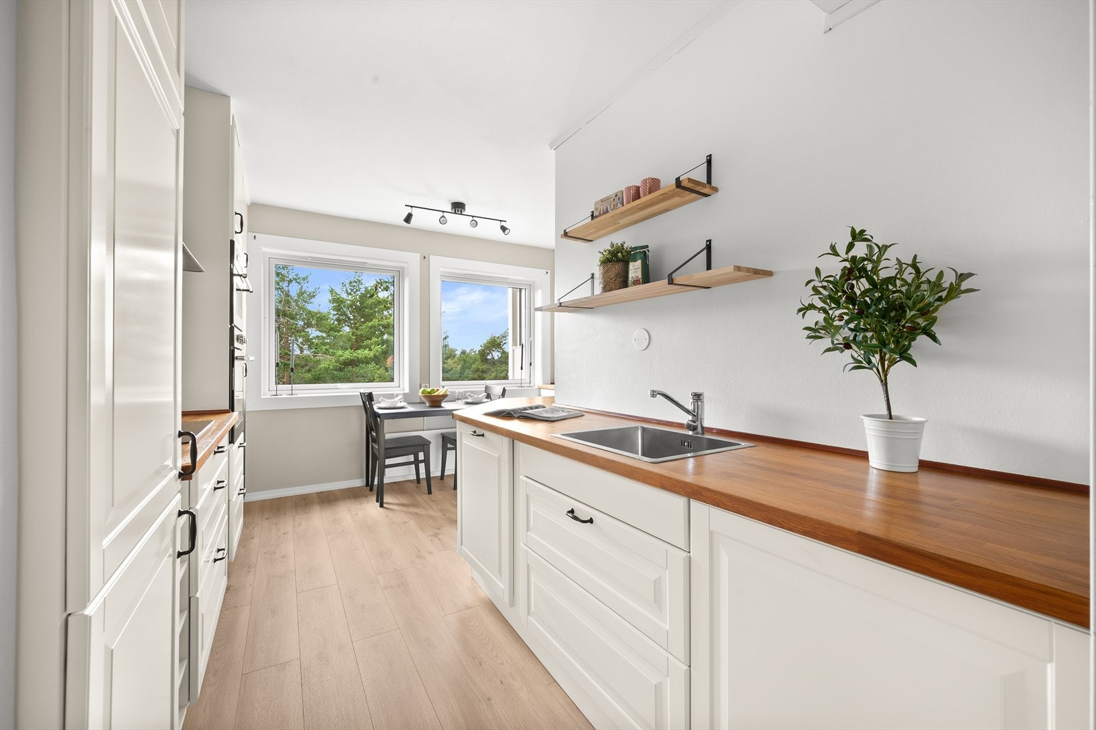 Pent, romslig kjøkken med hyggelig spiseplass ved vinduene. Galleribilde