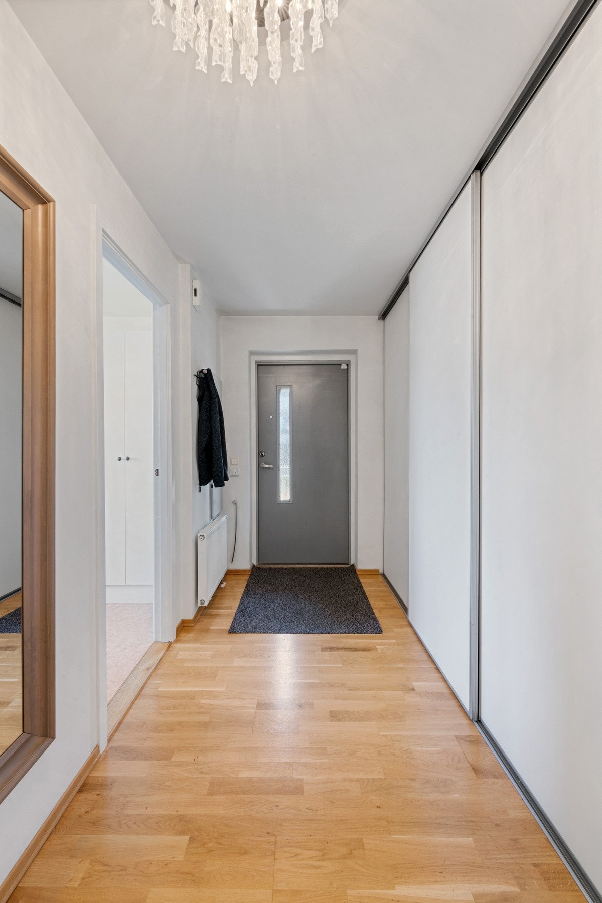 Romslig entré med praktisk skyvedørsgarderobe med god oppbevaringsplass. Galleribilde