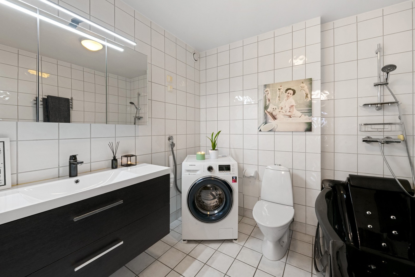 Stilrent og romslig baderom med flislagte vegger og gulv med varmekabel. Galleribilde