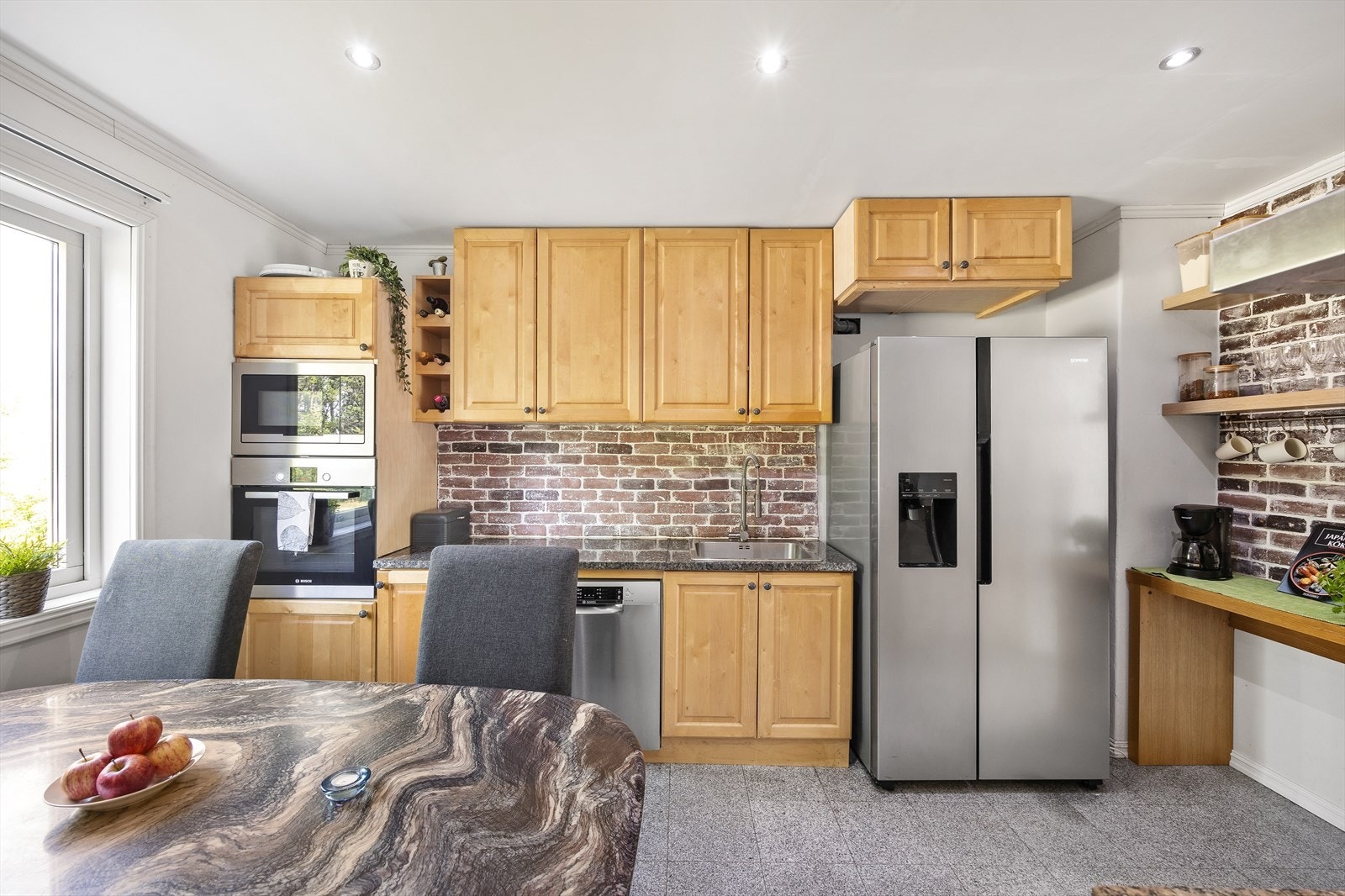 Kjøkkeninnredningen består av skap med profilerte fronter og benkeplate i stein. Galleribilde