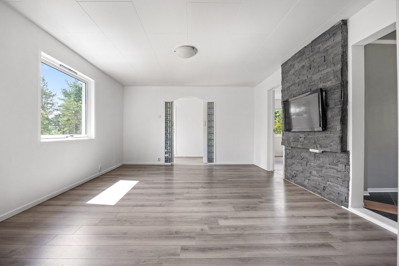 Stuen har et stort vindu som slipper inn rikelig med naturlig lys. Galleribilde