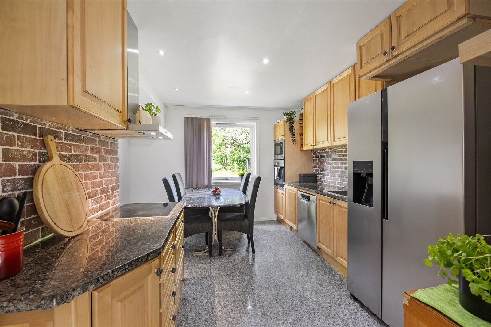 Kjøkkenet er innredet med integrerte hvitevarer som platetopp, komfyr og micro. Frittstående kjøleskap og oppvaskmaskin. Galleribilde