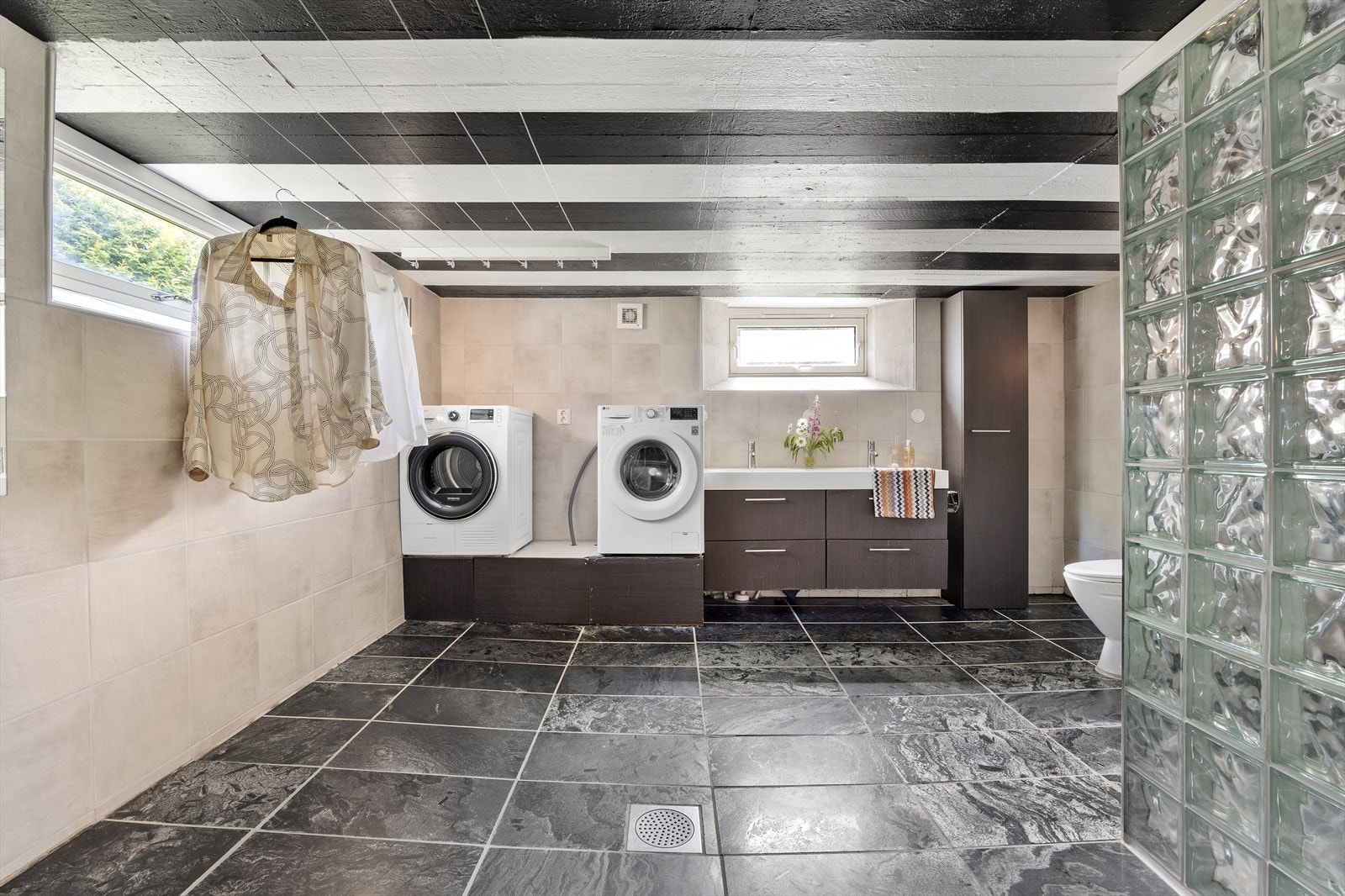 Baderommet er innredet med dobbeltservant, toalett, dusjhjørne og opplegg til vaskemaskin. Galleribilde