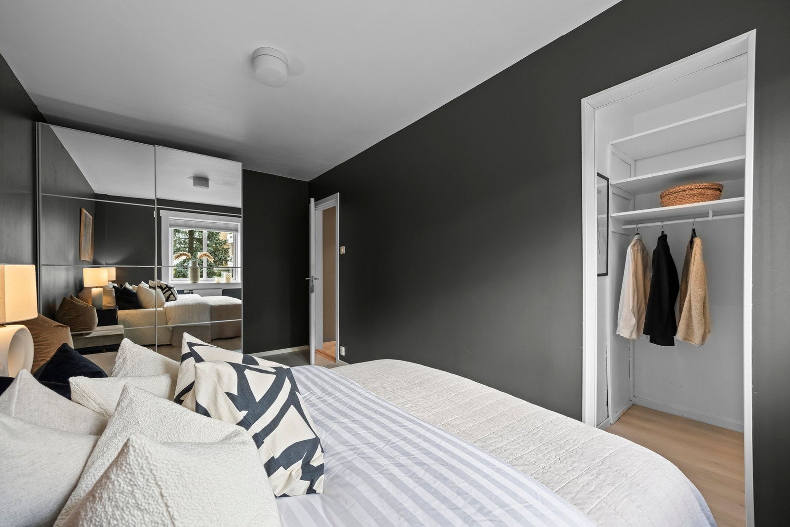 En stor skyvedørsgarderobe med speilfronter gir effektiv oppbevaring av klær og tilbehør. Galleribilde