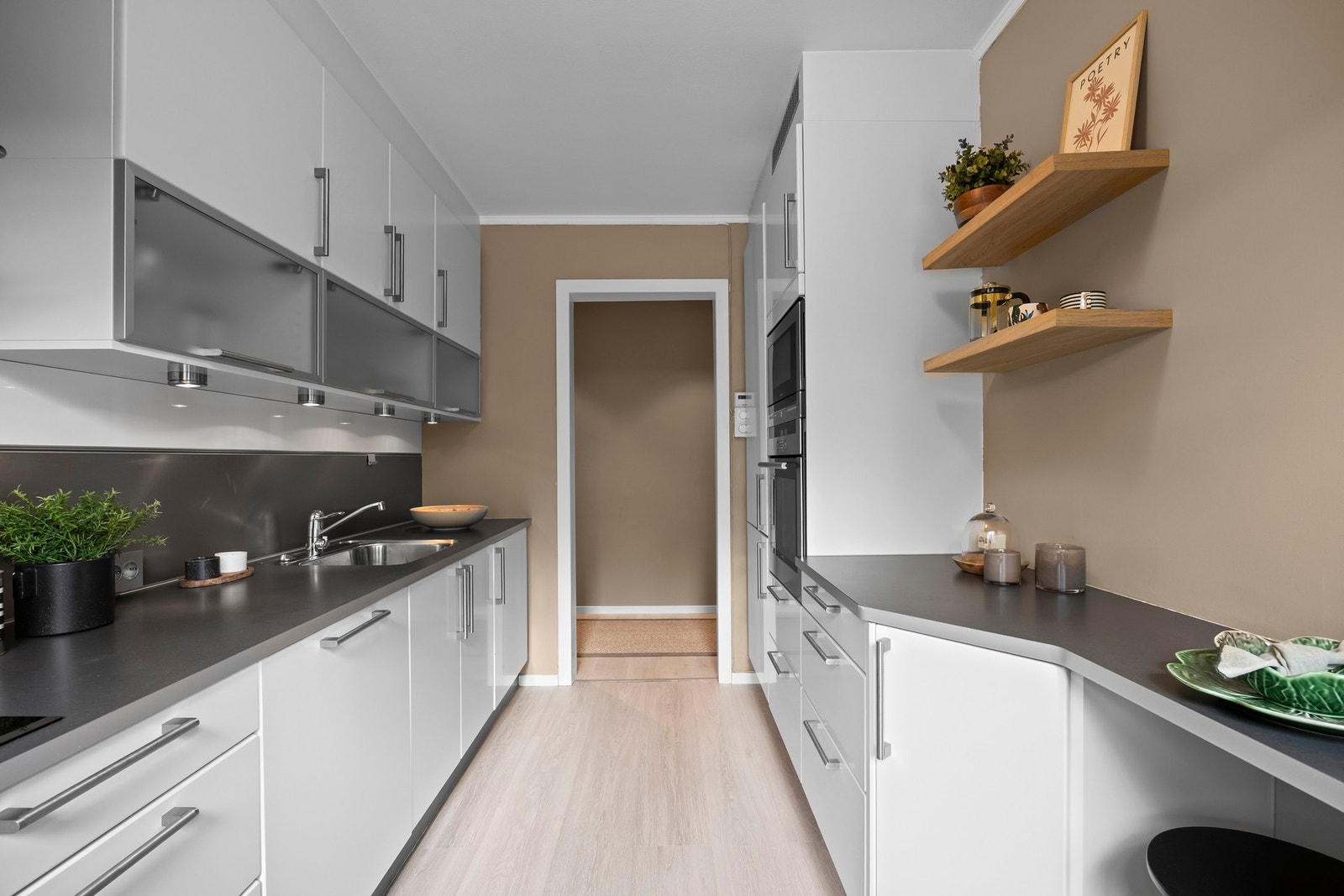 Integrerte hvitevarer inkluderer induksjonsplatetopp, stekeovn, mikrobølgeovn, oppvaskmaskin og kjøle-/fryseskap. Galleribilde