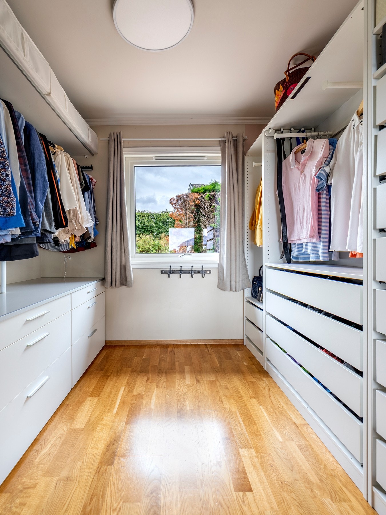 Fra hovedsoverommet er det inngang til garderoberom via frostede skyvedører inn til et velinnredet garderoberom med åpen skapinnredning, skuffer, hyller, kommoder og garderobestang. Galleribilde