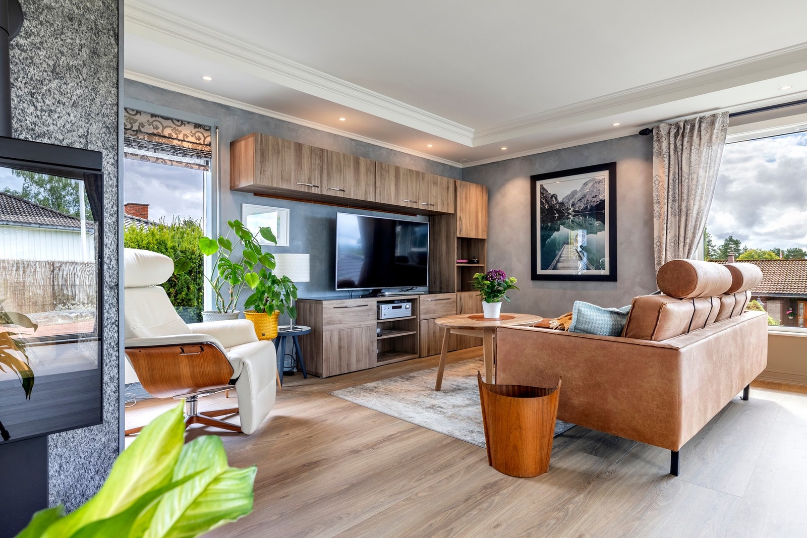 Stuen er et luftig og sosialt rom med åpen løsning til et moderne kjøkken, og god plass til både tv-lounge og spisestue. Rommet bades i dagslys fra skyvedører mot terrassen i vest, samt store vindusflater mot syd og øst. I indre hjørnet av stuen er det sa Galleribilde