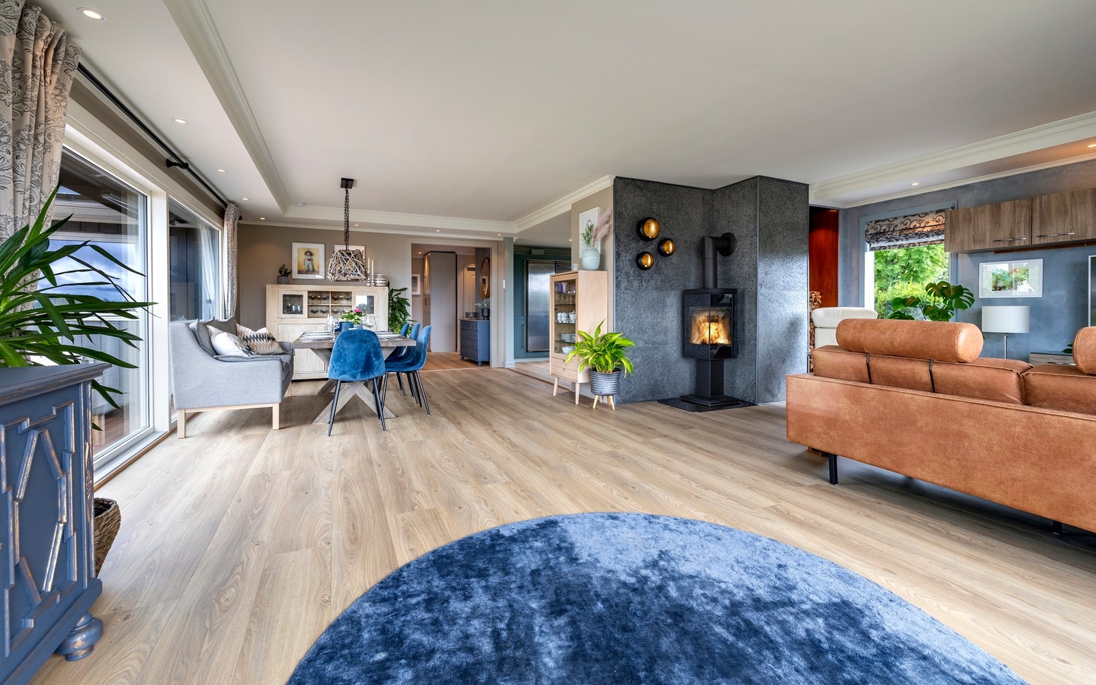 Stuen er utført med nyere laminatgulv i enstavs design, glatte, malte veggflater med innslag av kalkmaling og hvitmalt, glatt himling med nedfelte downlights langs kanten. Pipeløpet bak ildstedet er kledd i grå steinfliser og det er bygd en vednisje i bak Galleribilde