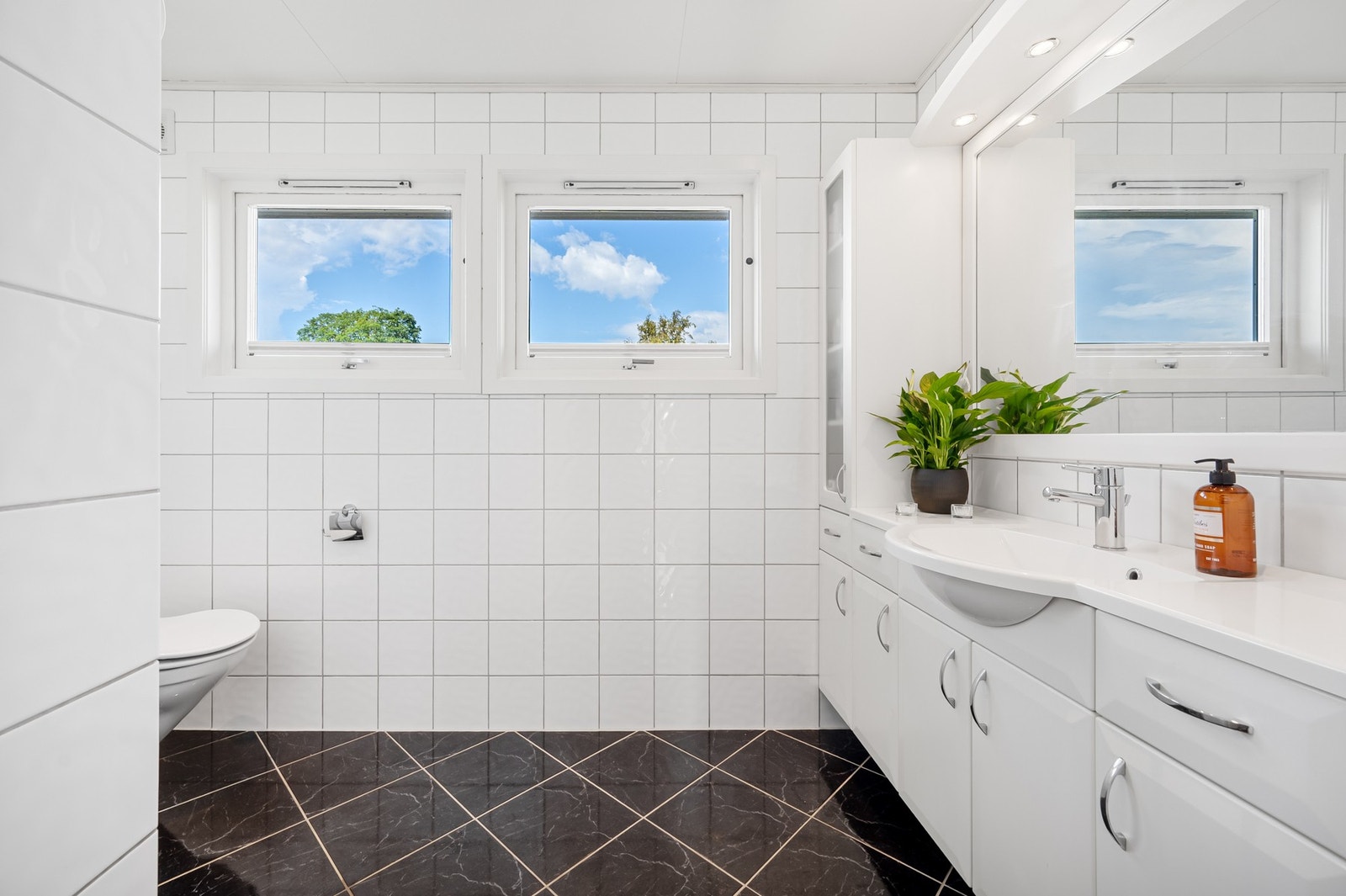 Flislagt bad med vegghengt toalett, baderomsinnrdning og dusjnisje. Galleribilde