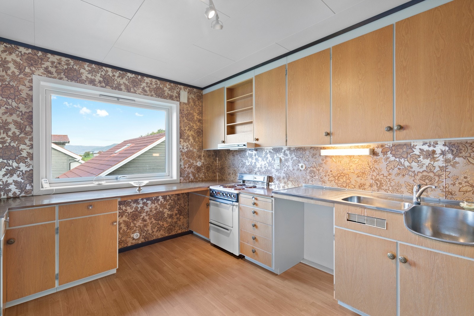 Kjøkkenet har innredning fra byggeår med slette, finerte fronter. Galleribilde