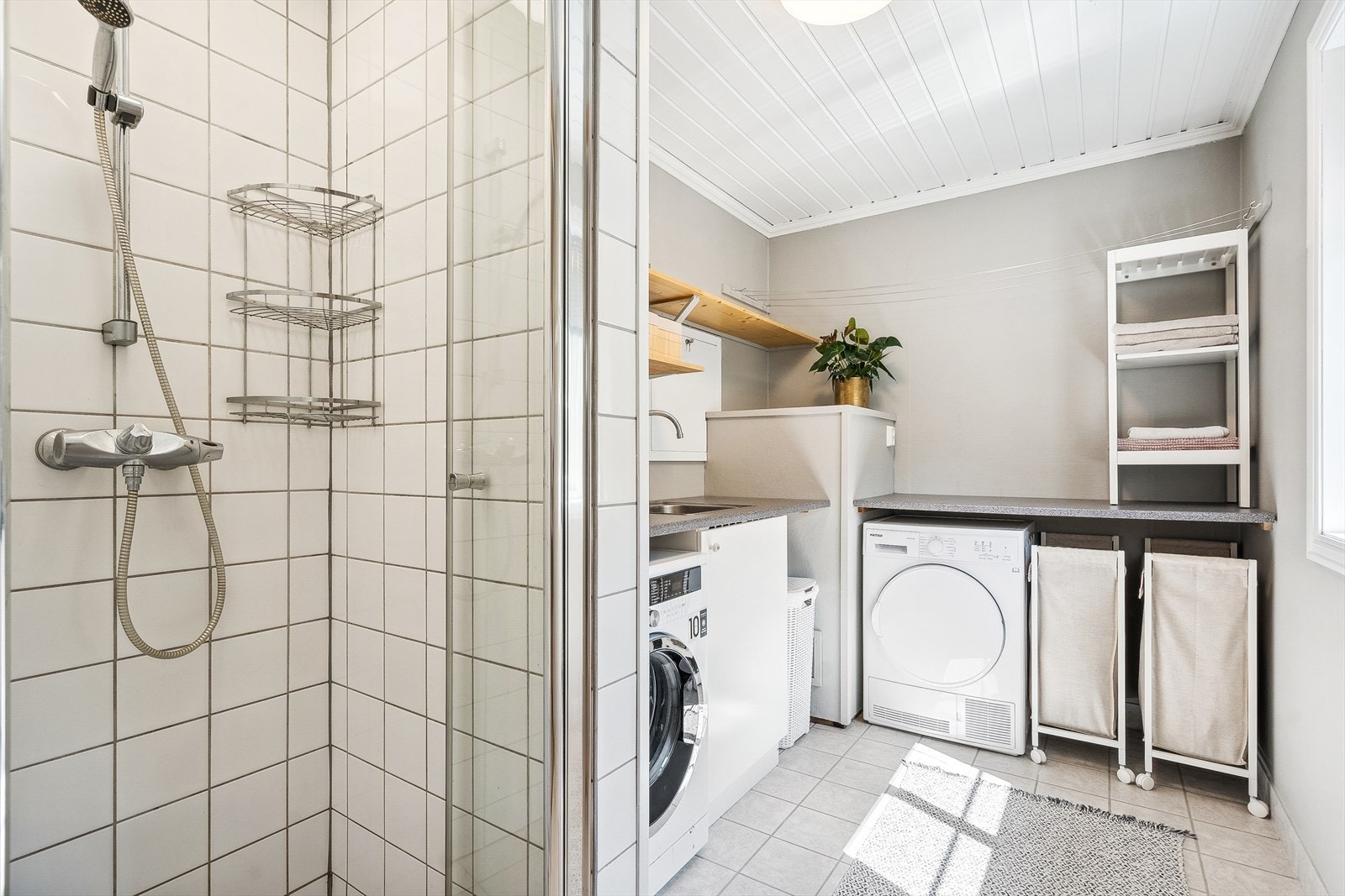 Vaskerom med dusj ligger vegg i vegg med badet. Meget funksjonelt rom med god plass til bretting av klær. Galleribilde