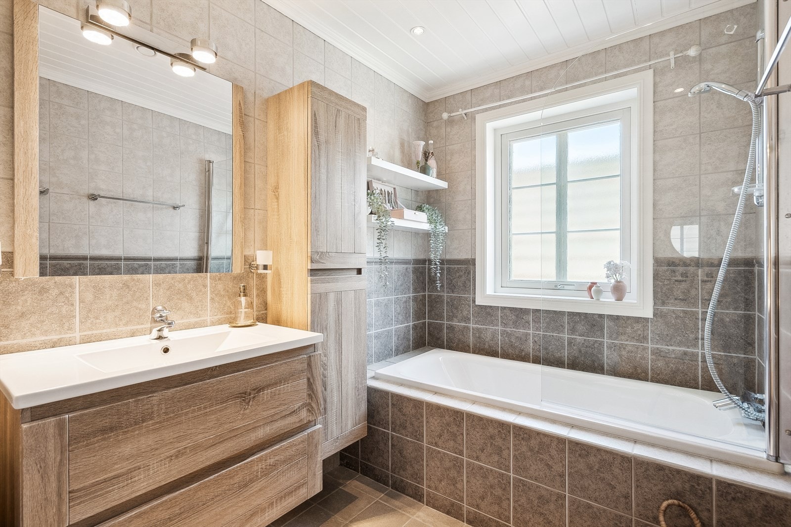 Badet inneholder servant i innredning, wc og badekar med dusjløsning Galleribilde