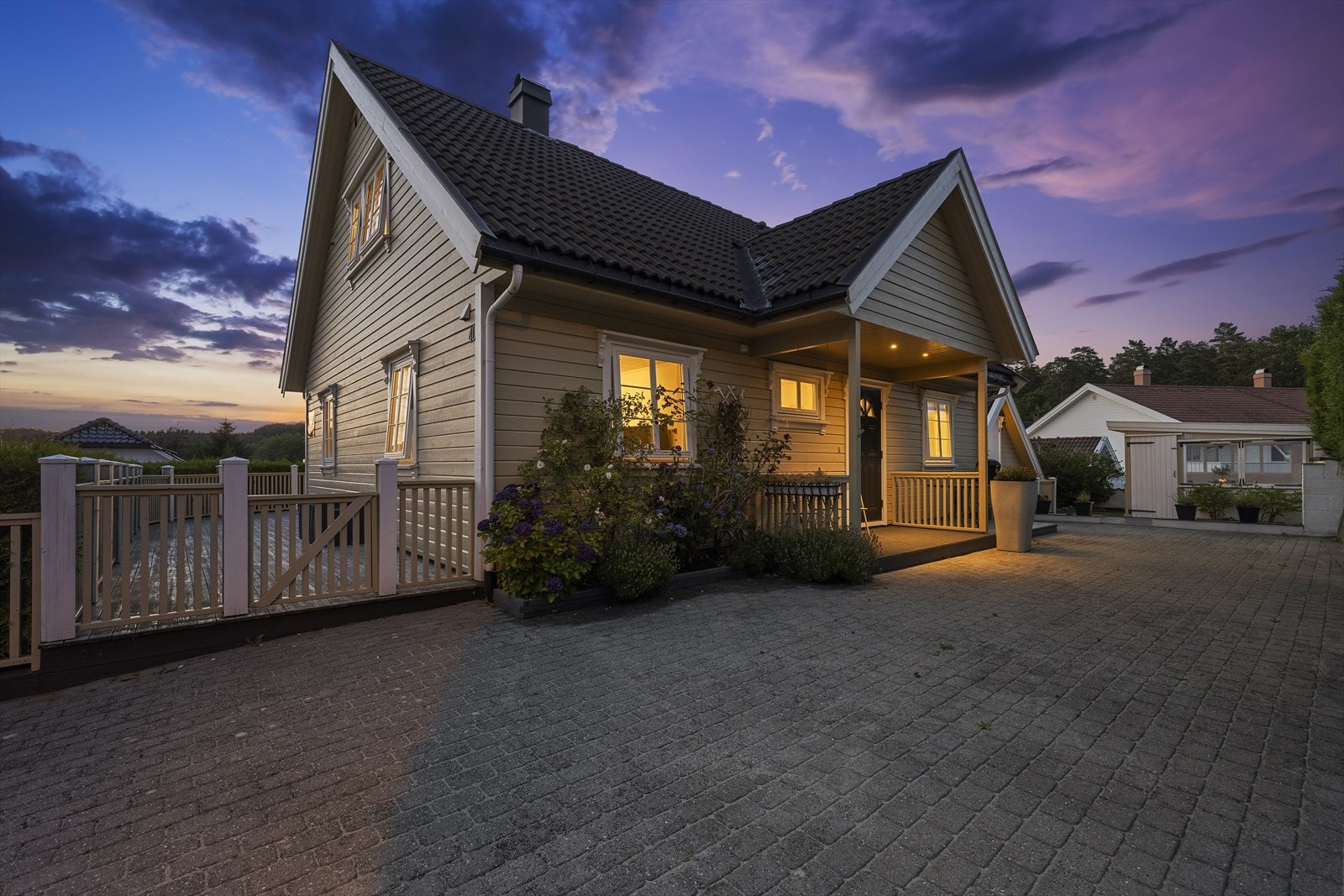 Inngangsparti i kveldsstemning. Praktisk med stor uteplass med belegningsstein. Galleribilde