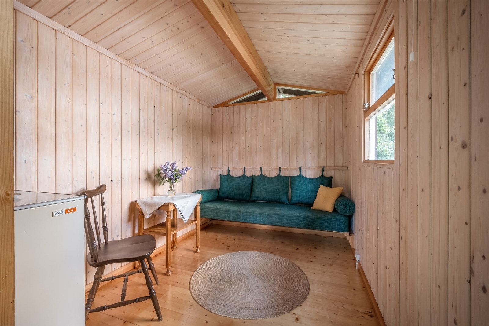 Uthuset har stående panel på vegger, parkett på gulv og plass til diverse møbler. Galleribilde