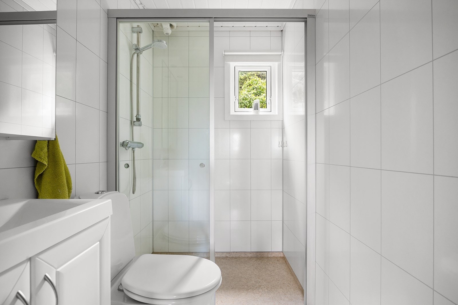 Badet er funksjonelt og inneholder alt du måtte trenge; en servant nedfelt i benkeskap, speilskap, toalett og dusjhjørne. Praktisk og enkelt - akkurat slik det skal være på en hytte. Galleribilde