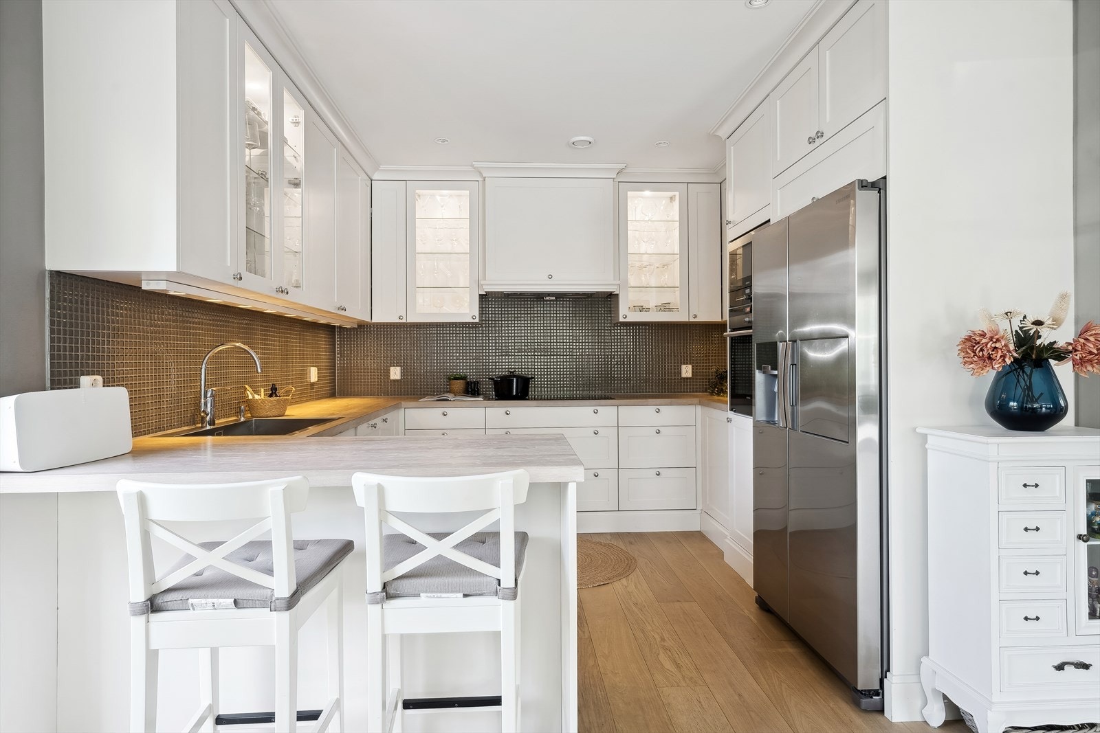 Kjøkkeninnredningen er fra Pigo Møbler og har hvite profilerte fronter Galleribilde