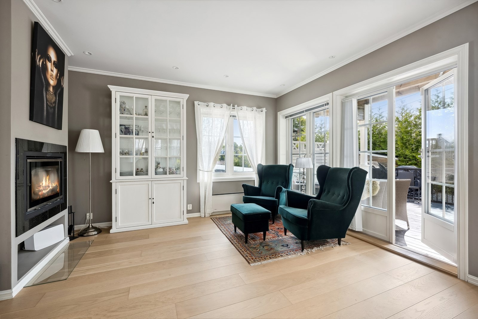 Stuen har en hyggelig peis og videre utgang til en solrik markterrasse Galleribilde