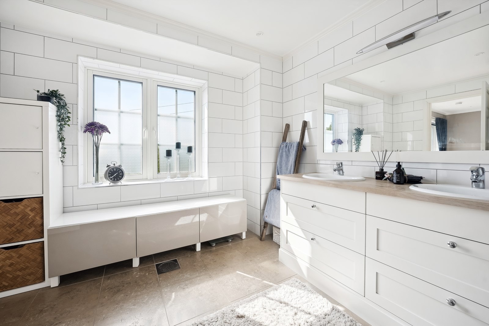 Badet er innredet med dobbel servant, rikelig med skapplass, veggfestet wc og dusj på gulv Galleribilde