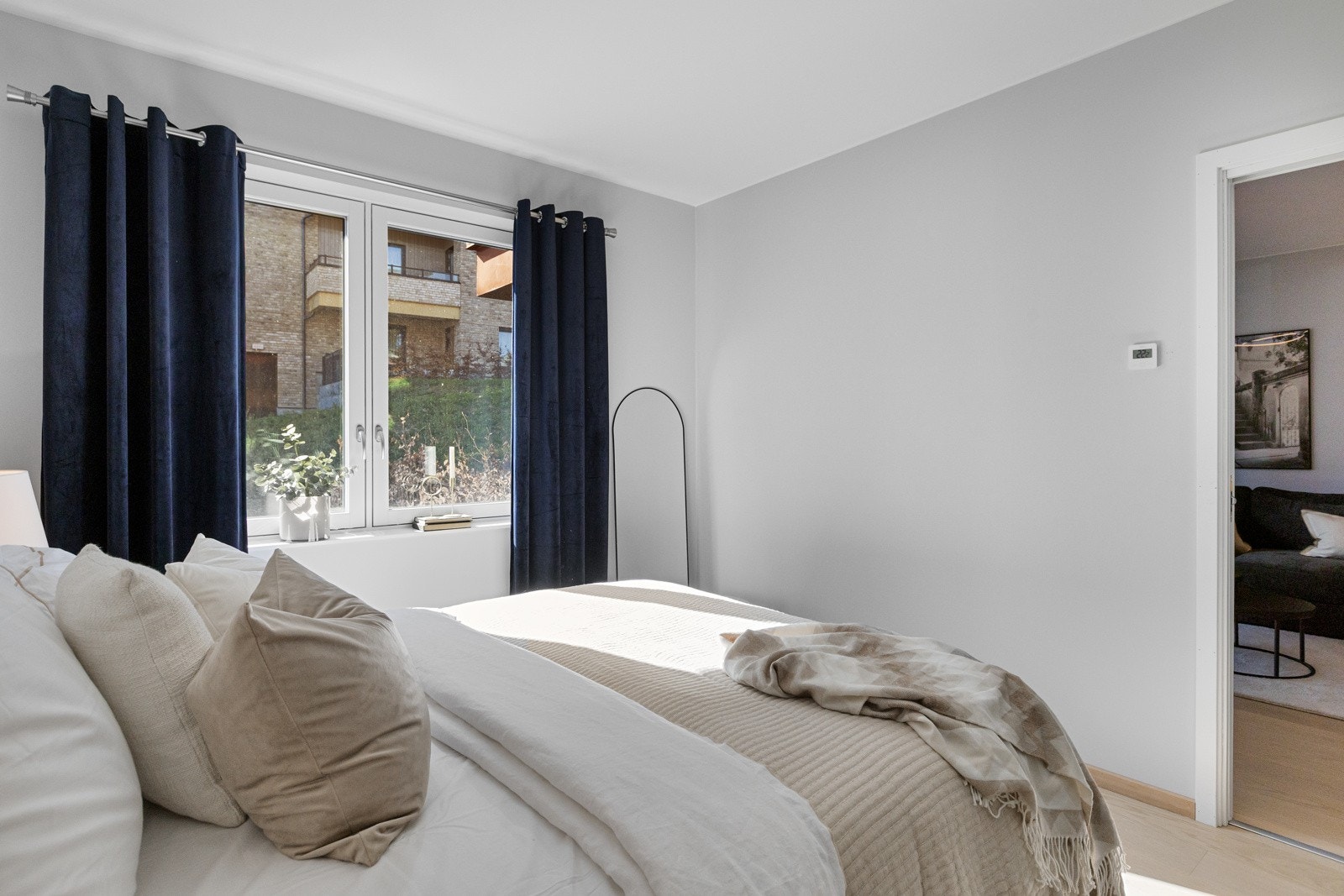 Rommet har store vinduer som slipper inn naturlig lys og gir flott utsikt mot grønne omgivelser Galleribilde